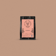 Coffee package with a pink label on a brown background